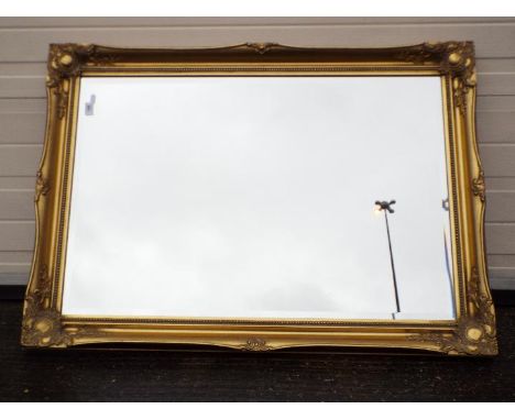 A gilt framed, bevel edged wall mirror, approximately 76 cm x 105 cm.All items must be paid for and collected by close of bus
