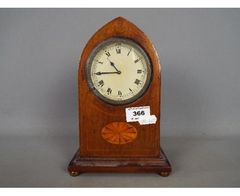 A mahogany cased lancet top mantel clock, Roman numerals to a white dial. 