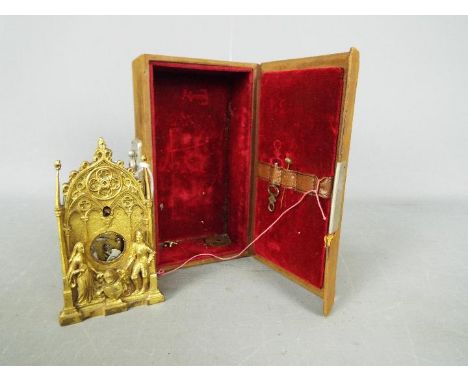 An early 19th century, good quality miniature cast brass Gothic styled zappler clock, two train movement striking on a coiled