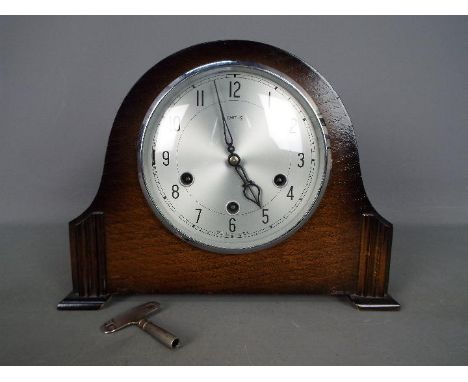 An oak cased Smiths mantel clock with key and pendulum.