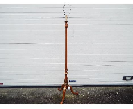 A wooden standard lamp on tripod supports with gilt detailing, approximately 150 cm (h)