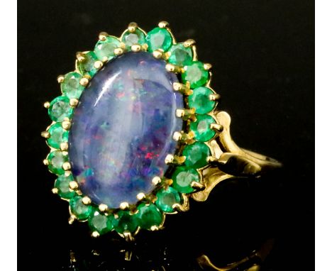 An Opal and Emerald Ring, Modern, in 9ct gold mount, set with an oval opal, approximately 10mm x 14mm, surrounded by twenty r