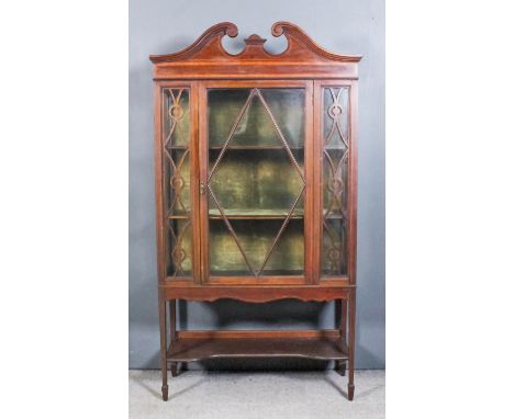 A Mahogany Display Cabinet, Edwardian, the whole inlaid with stringings, the upper part with moulded scroll pediment and inla