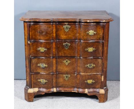 A Dutch Walnut Commode, 18th Century, of small proportions, the whole of shaped outline, the top inlaid with circular panel w