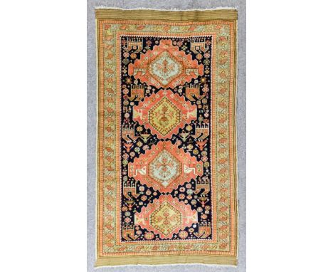 An Unusual Caucasian Rug woven in colours with four stepped lozenge shaped medallions, the field filled with stylised figures