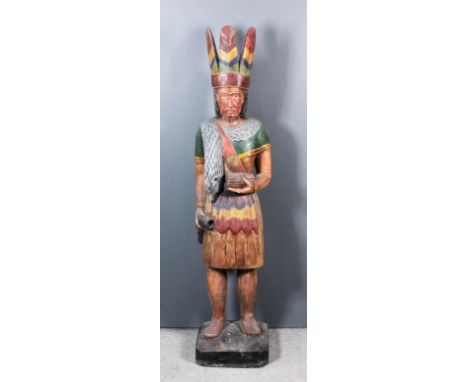 A Standing Carved and Painted Figure of a Native North American, Modern, holding a quantity of cigars in his left hand, a fla