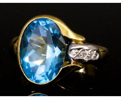 A Blue Topaz and Diamond Ring, Modern, in 18ct gold mount, set with an oval faceted topaz, approximate weight 4ct, with four 