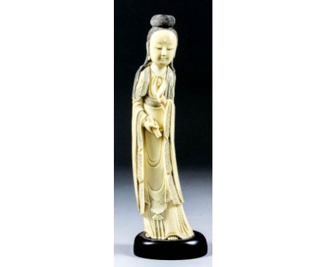 A Chinese Carved and Stained Ivory Standing Figure of Guanyin, late 19th/early 20th Century, holding a scroll, 10.25ins (26cm