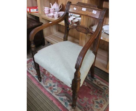 A Regency design mahogany open arm chair with entablature splat raised on ring turned fore supports, with stuffed over-seat