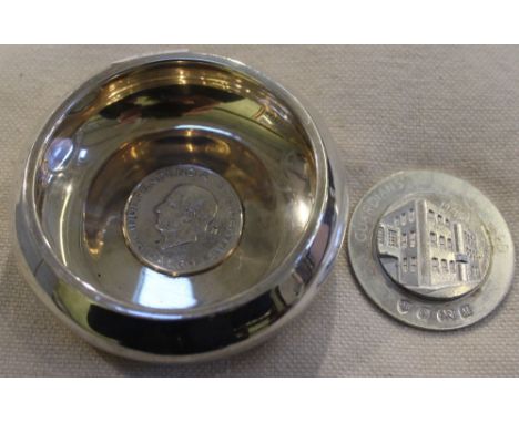 A silver dish together with a medal
