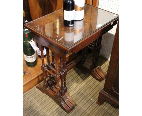 A nest of three intersliding coffee tables, raised on ring turned supports, largest 36cm x 51cm