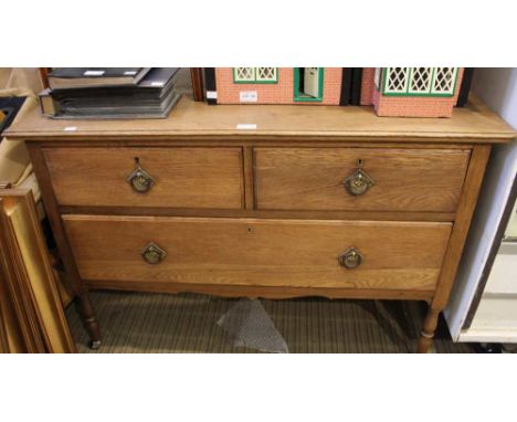 An oak chest of two short over one long drawer with ring handles on turned supports, 105cm wide