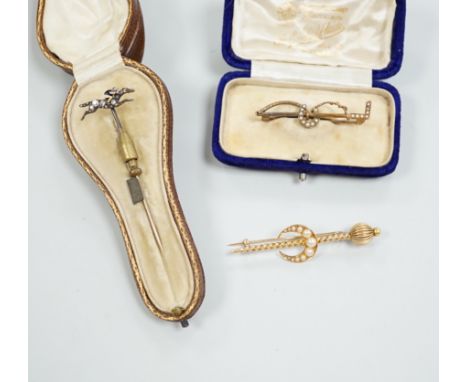 An Edwardian enamel and diamond set 'horse and jockey' stick pin, 63mm, a yellow metal and seed pearl set 'crescent and staff