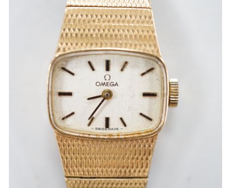 A lady's Omega 9ct gold manual wind wrist watch, with integral 9ct gold bracelet, gross weight 31.3 grams.