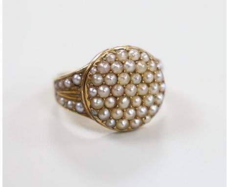 An Edwardian 15ct and seed pearl cluster set dress ring, with seed pearl set shoulders, size J/K, gross weight 5.6 grams, in 