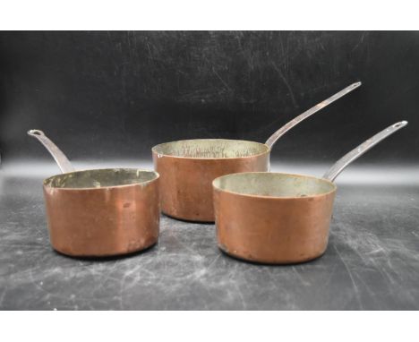 A set of three vintage copper saucepans. 