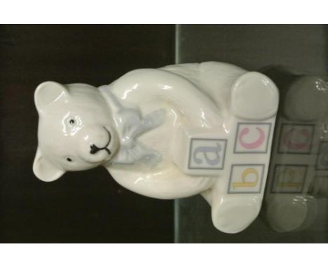 BELLEEK/CERAMIC/IRISH: A sweet Belleek seated teddy bear figurine with blue bow and a base of alphabet letter blocks. Ideal b