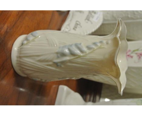 BELLEEK/CERAMIC/IRISH: An elegant Belleek vase with a wavy rimmed design. In cream leaves pattern with an overlay  of blue fl