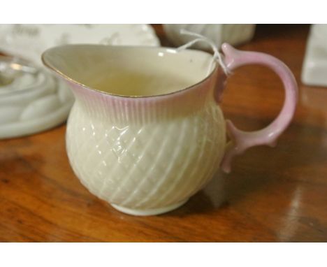 BELLEEK/CERAMIC/IRISH: A Belleek small creamer/milk jug in a thistle head design. Pink blush trim at neck and handle. Matchin