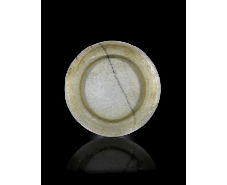 A LARGE CHINESE CELADON JADE DISH, FOUR CHARACTER QIANLONG MARK AND OF THE PERIOD 1736-95 Carved in shallow relief with a scr