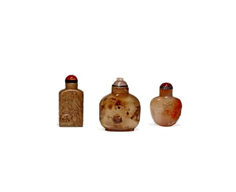 λ THREE CHINESE SNUFF BOTTLES, 19TH CENTURY Two in agate, another in brown jade, carved in relief with flowers, a tiger in a 