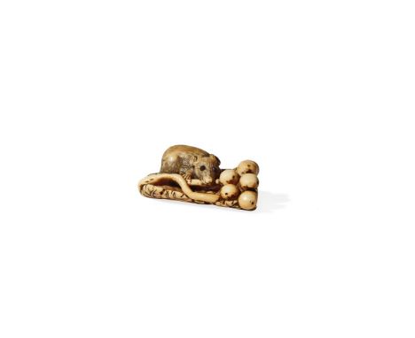 † A JAPANESE IVORY NETSUKE, 19TH CENTURY Carved as a squirrel resting on a cluster of leaves and gnawing on berries, the eyes