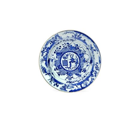 A LARGE CHINESE BLUE AND WHITE DISH, KANGXI 1662-1722 The well with a central convex roundel painted with a gnarled prunus tr