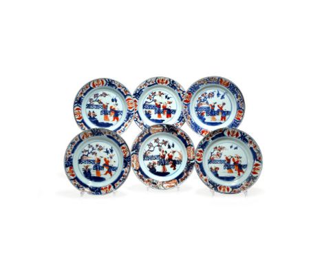 A SET OF SIX CHINESE IMARI PLATES, EARLY 18TH CENTURY Each depicting a lady in a fenced garden, with two young boys playing b