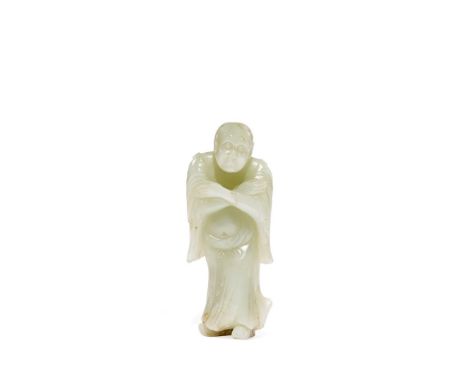 A CHINESE PALE CELADON JADE MODEL OF A MONK, QING DYNASTY Standing with his arms crossed in front of his chest, his long slee