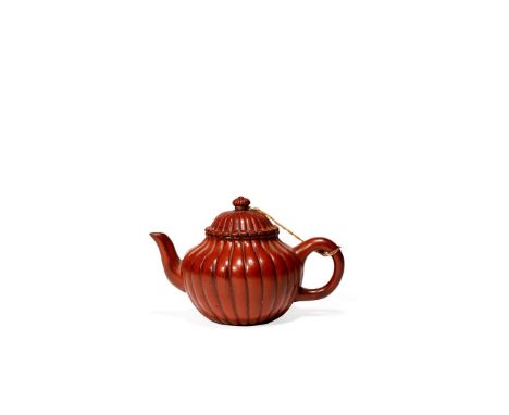 A SMALL CHINESE YIXING TEAPOT AND COVER, 19TH CENTURY The ovoid body lobed to simulate a chrysanthemum flower, the finial for