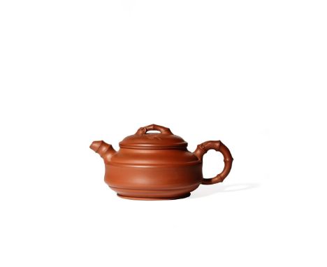 A CHINESE YIXING TEAPOT AND COVER, REPUBLIC PERIOD The compressed circular body with concentric bands, the handle, spout and 