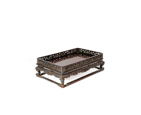 A SMALL CHINESE HARDWOOD STAND OR TRAY, QING DYNASTY The rectangular top with reticulated stylized dragon friezes, raised on 