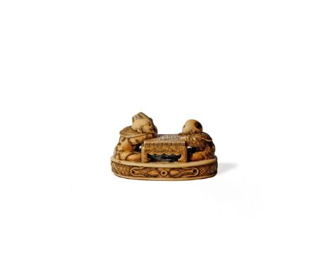 † A JAPANESE IVORY NETSUKE, 19TH CENTURY Depicting two boys playing elephant chess on an oblong base, one holding a large pot