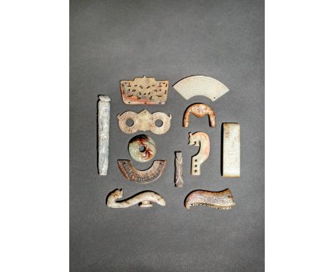 TWELVE CHINESE JADE ITEMS, QING DYNASTY Variously carved as plaques, a belthook, a sword slide and a bi disc, decorated with 