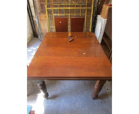 An Edwardian walnut extending dining table, the top with canted corners and moulded edge, on turned legs and ceramic castors,