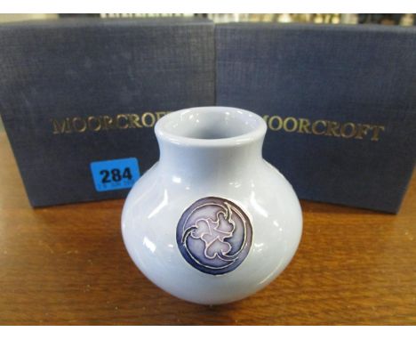 A boxed, Moorcroft shouldered, ovoid vase with Arts & Crafts floral medallions, against a light blue ground 