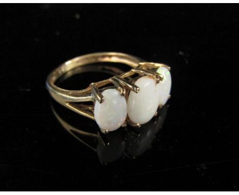 A 9ct gold ring set with three oval opals. Size L/M, 2g 