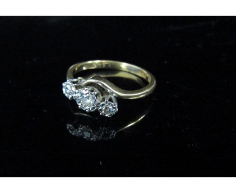 A gold ring with three diamonds in crossover setting, stamped 18ct/plat. Size M, 2.9g 