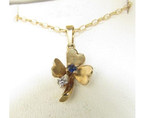 A 9ct gold clover leaf pendant set with single sapphire and diamond, hung on a fine gold chain stamped 9k, 40cm long, 1.6g 