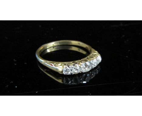 A gold ring set with five graduated diamonds, stamped 18ct, centre stone 0.20ct approx. Size Q/R, 3.2g 