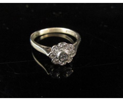 A gold diamond daisy ring in rubover setting, marked 375. Size N, 2.5g 