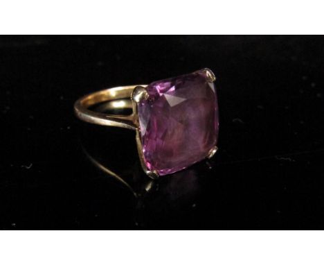 An unmarked gold ring set with a large square purple stone, possibly a synthetic violet sapphire. Size O/P, 6.6g 