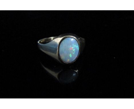 A 9ct gold ring with oval opal in rubover setting. Size I/J, 1.3g 