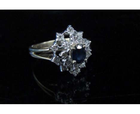 A 9ct gold diamond and sapphire cluster ring, open shoulders. Size N, 3g 