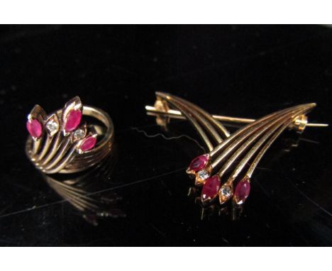 A ruby and diamond ring in a crossover spray setting, stamped 14k. Size L/M with a matching brooch, marked 18k, 8.9g 