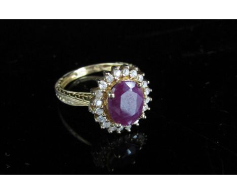 A 9ct gold ruby and diamond ring, the central ruby 10mm x 8mm framed by diamonds, engraved half shank. Size N, 3.5g 