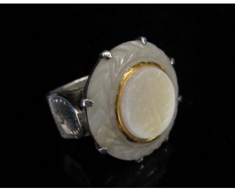 A carved white jade ring in claw setting, in a heavy white metal shank. Size N 