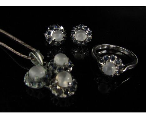 A suite of moonstone and sapphire jewellery comprising of a pair of earrings, pendant on chain and a ring. Size M/N, on unmar
