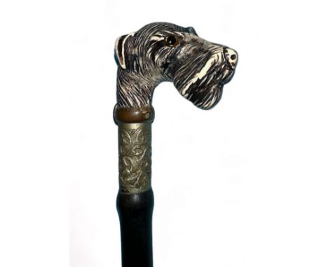 Ebonised sword stick with a dogs head, possibly a terrier, dog has a brass collar with buckle. Very ornate top ferrule with a