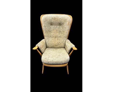 An Ercol mid 20th Century Evergreen beech and elm armchair. The chair having the large wingback spindle back and shaped armre
